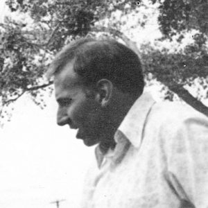 Profile view of white man in shirt talking outdoors