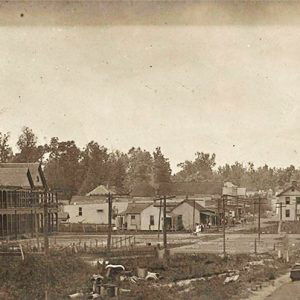 View from top of train cars of multistory and single-story buildings on town streets