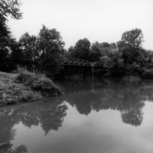 Large creek with steel arch truss bridge