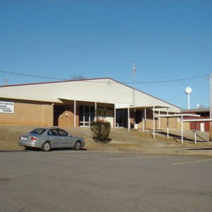 Single-story brick building with covered walkway entrance and parking lot