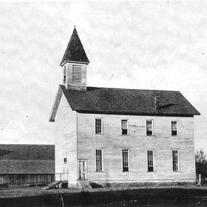 two story white wooden church building with bell tower