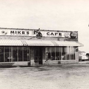 Single-story building with awning next to "Mike's Cafe"  sign