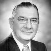 White man with glasses in suit and decorative tie