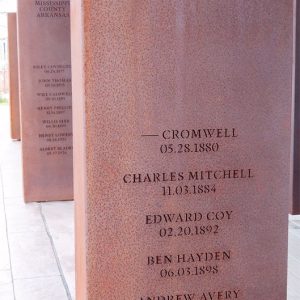 Rust-colored metal rectangle engraved with names and locations