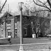 Two-story courthouse with trees and street lamps