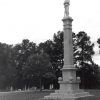 Soldier with a gun on top of stone obelisk shaped monument