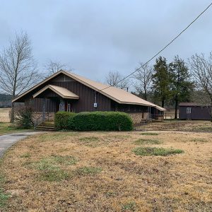 Church building with dark colored siding and outbuilding