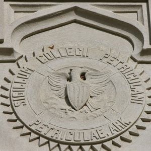 Round logo with eagle Latin text and shield etched onto building