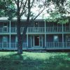 Blue and white two-story house with covered porch and covered balcony across the entire front