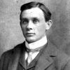 Young white man in suit and tie with white collar