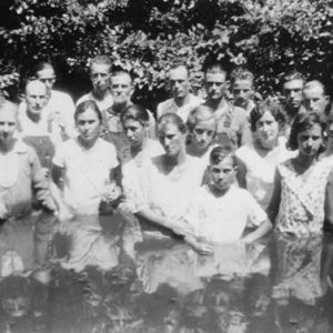 Group of white men and women standing in body of water