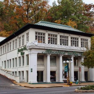 Three-story building "Mountain Valley Water" and street with trees and parking lot