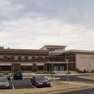 Two-story brick school building with street lamps and parking lot