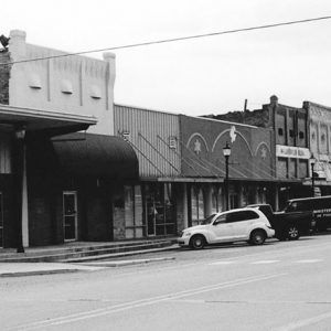 Brick storefronts and parked cars on street