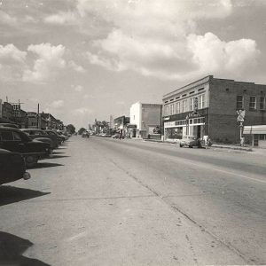 Parked cars and multistory buildings on town street