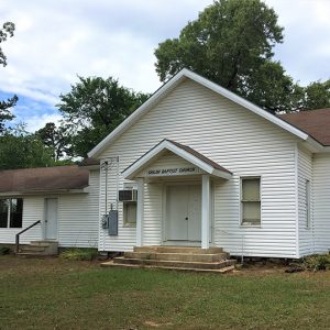 Single-story white church building with "Shiloh Baptist Church" sign above front door