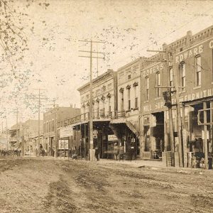 Multistory buildings and power lines on dirt street