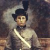 Young white man sitting in gray military uniform with hat and sword in his lap