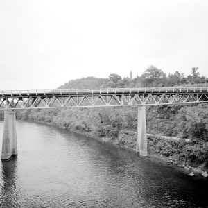 Concrete and steel bridge over river with concrete supports