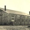 Stone building with double doors and brick chimneys