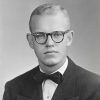 Young white man with glasses in suit and tie