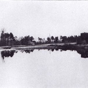 Wooden tower beside pool of black liquid