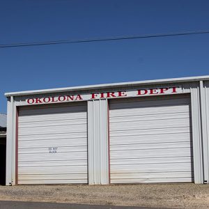 White three-bay garage building with single-story extension