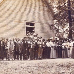 Crowd of white men and women outside church building