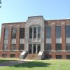 Multistory brick building with steps and prominent glass windows