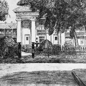 Neoclassical building with four columns and iron fence on street