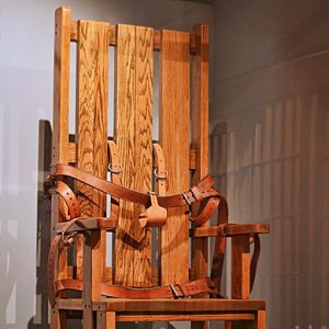 Wooden electric chair with leather straps on display