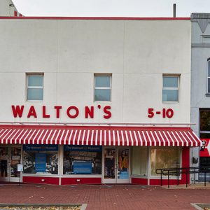 "Walton's" storefront building with red and white striped awning over sidewalk