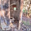 Interior of abandoned outhouse in forest