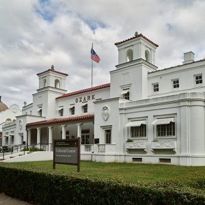 Multistory white building with ornate windows and the word "Ozark" on the front