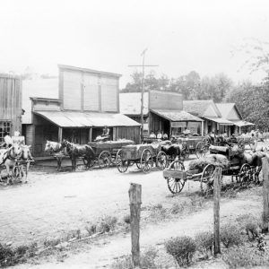 Street lined with buildings busy with wagons and car