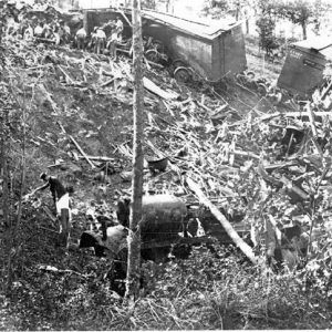 Men looking through the wreckage of a train crash on a wooded hill side