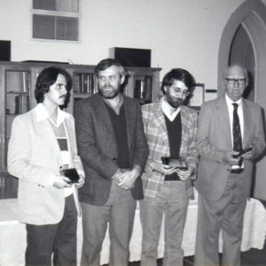 Group of four white men holding trophies