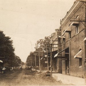 Dirt road lined with multistory storefronts