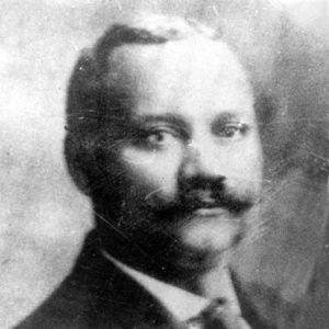 African-American man with mustache in suit and tie