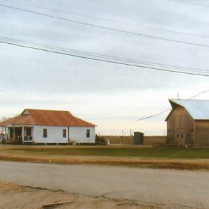 Single-story house with rusted metal roof outbuilding and barn