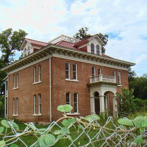 Three-story brick building with red roof