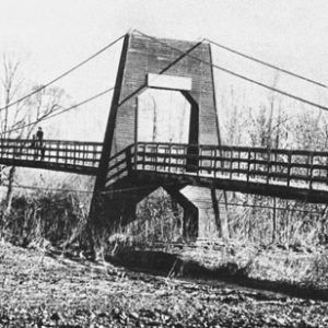 Wooden suspension bridge over river with railings