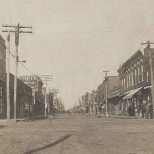 Street between rows of multistory brick buildings and power lines on both sides