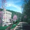 Multistory hotel building with paved walking path and benches in the foreground