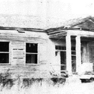 Run-down abandoned single-story house with covered porch