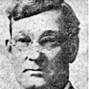 Old white man with glasses in suit and bow tie