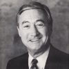 Older white man smiling in suit and tie