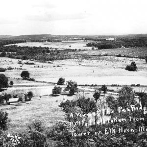 Overlook view of rolling hills farmland roads and river with twin plateaus in distance