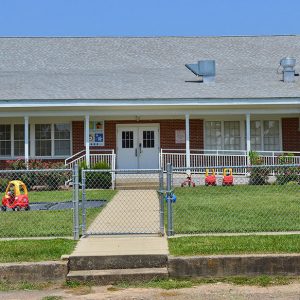 Close-up of brick school building with fenced in yard