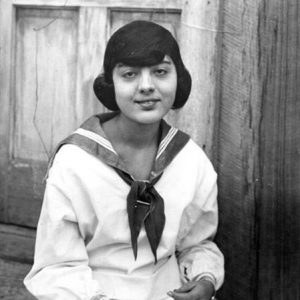 Young white girl in dress with neckerchief and book